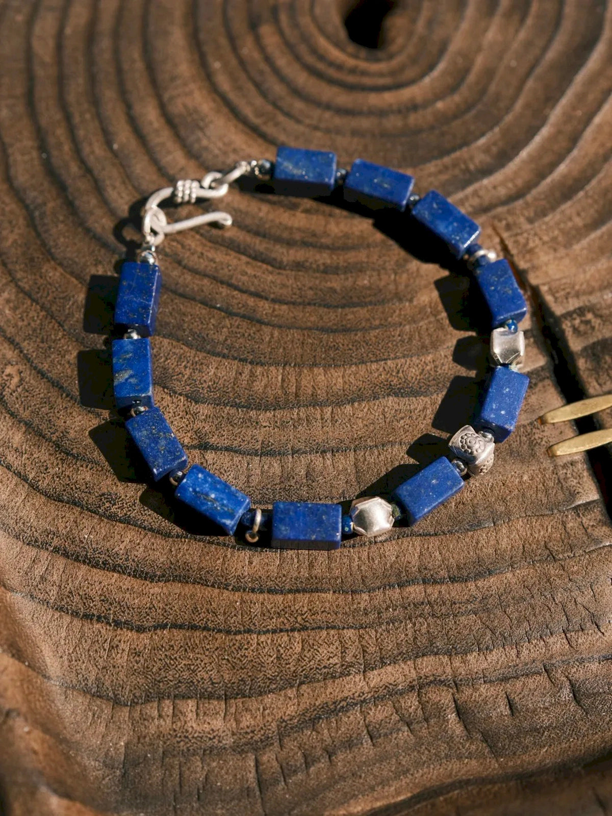 Full view of the Blue Vanguard bracelet with rectangular lapis lazuli beads, fine silver accents and a silver hook closure.