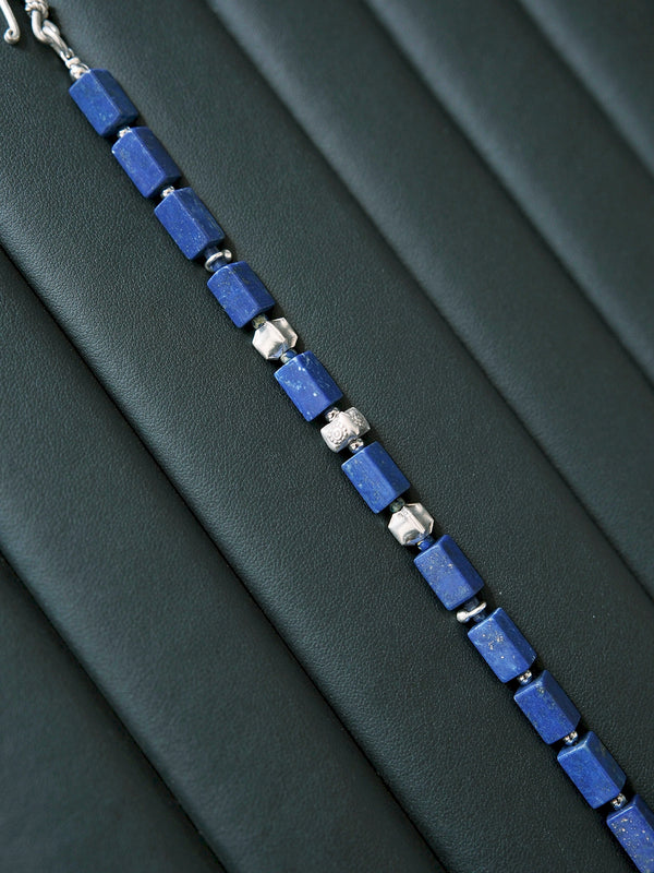 Rectangular lapis lazuli and fine silver bracelet displayed on black leather, highlighting the deep blue color and silver texture.