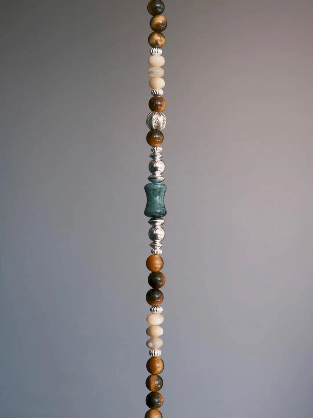 Vertical product view of the Ochre Monarch bracelet highlighting tiger eye, mother-of-pearl, green agate and sterling silver details