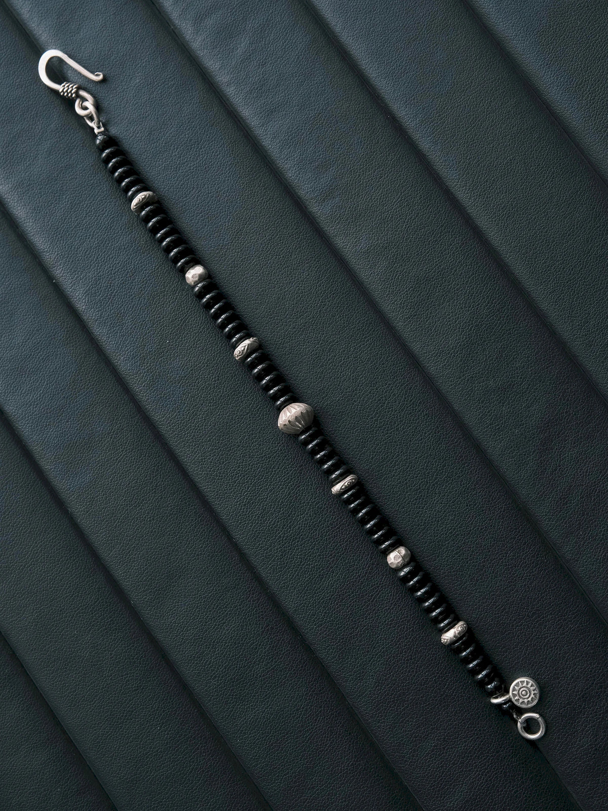 Monochrome menswear mood image featuring the Dawn Sentinel black onyx and silver bracelet