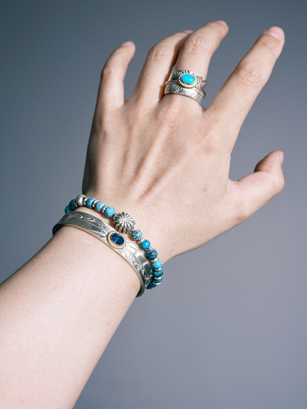 Sun Seeker turquoise bracelet on a wrist, with the silver eagle and circular clasp shown beside a cuff.