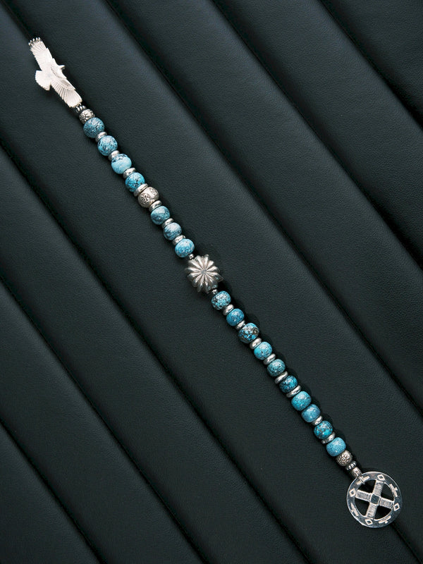 Sun Seeker turquoise bracelet laid diagonally in a straight line, with an eagle at one end and a circular ring at the other.