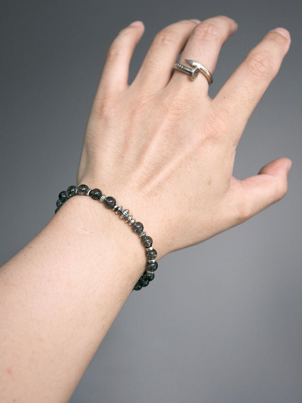 Shadow Sentinel bracelet worn alone on the wrist, with geometric silver-tone details facing upward.
