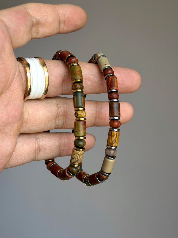 Gold-tone and silver-tone Earth Nomad bracelets held side by side to show their different spacer finishes.